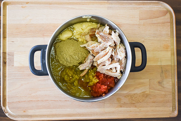 creamy green chile sauce ingredients added to medium cooking pot