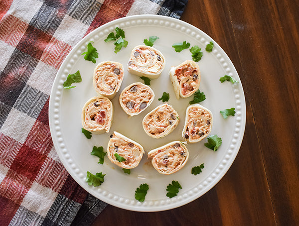 fiesta chicken tortilla roll ups/ pinwheels on plate ready to serve garnished with cilantro