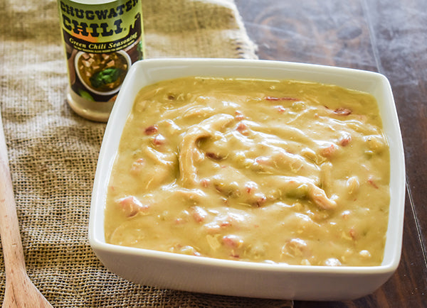 creamy green chile sauce in bowl with jar of chugwater chili green chili seasoning behind it