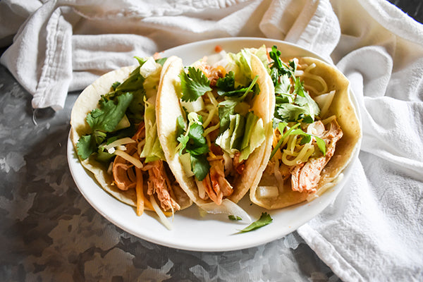 Shredded chicken tacos on plate