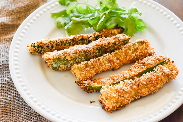 baked zucchini fries on plate with cilantro garnish ready to eat