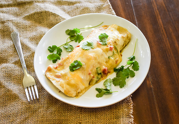 chicken enchiladas in creamy green chile sauce on plate ready to eat