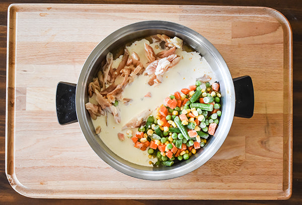 shredded chicken,  mixed vegetables, heavy cream, and chicken broth added into pot with seasoned roux
