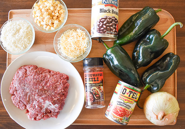 ingredients for southwest stuffed poblano peppers, ground beef, poblano peppers, shredded cheese, black beans, onion, rice, diced tomatoes with green chilies, chugwater chili seasoning, corn