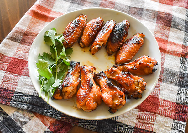 Chili Pineapple Chicken wings on plate with cilantro garnish