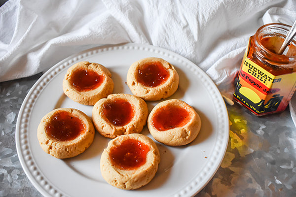 red pepper jelly thumbprint cookies on plate with Chugwater chili red pepper jelly jar