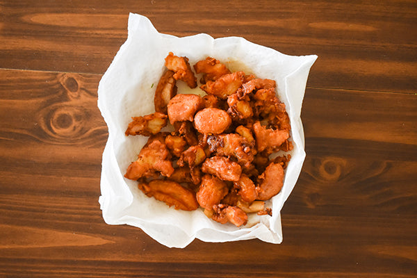 cooked/fried chili beer battered cod on paper towel to drain