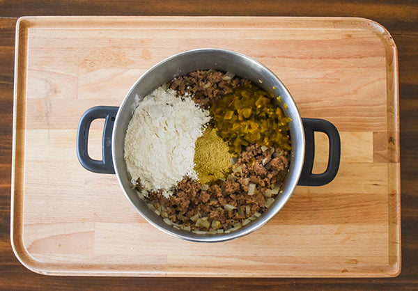 flour, diced green chilies, and Chugwater Chili green chili seasoning added to pot with browned pork sausage