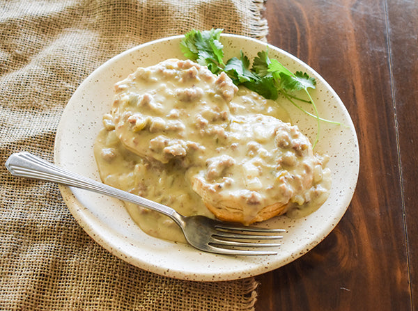 creamy green chile gravy over biscuits ready to serve