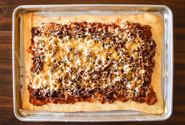 baked taco pizza before added taco toppings