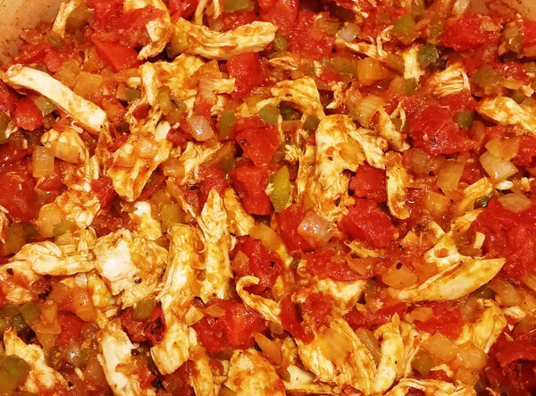 close-up photo of the tomatoes added to the pot with the chicken