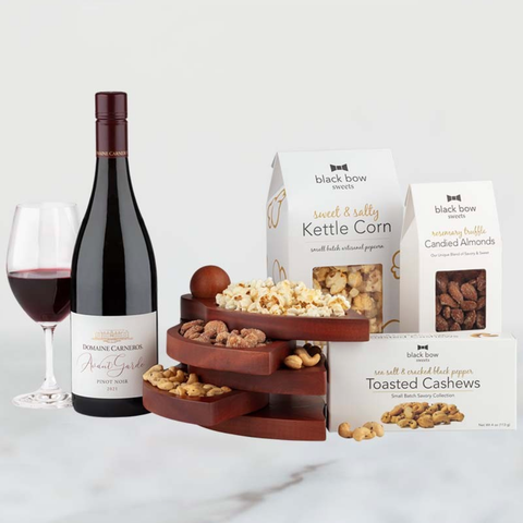 Image shows Domaine Carneros Pinot Noir with Black Bow Sweets rosemary truffle candied almonds, salt and pepper cashews and kettle corn with wooden serving tray.