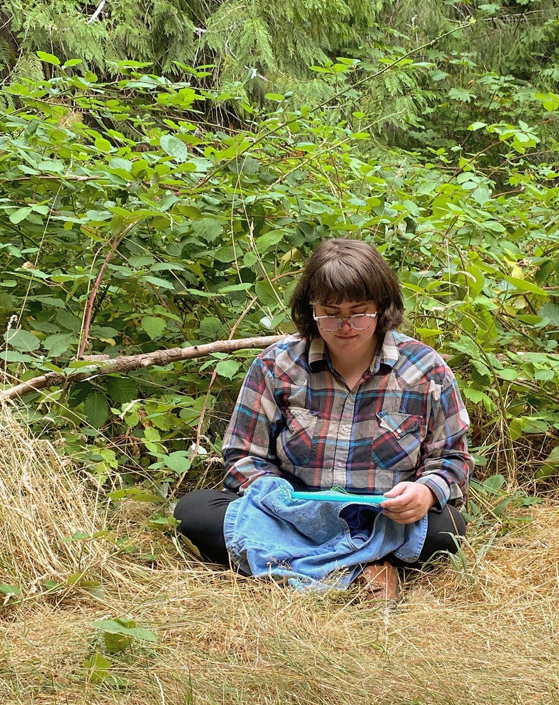 embroidery artist lee caroline mackey, sitting sewing in the woods