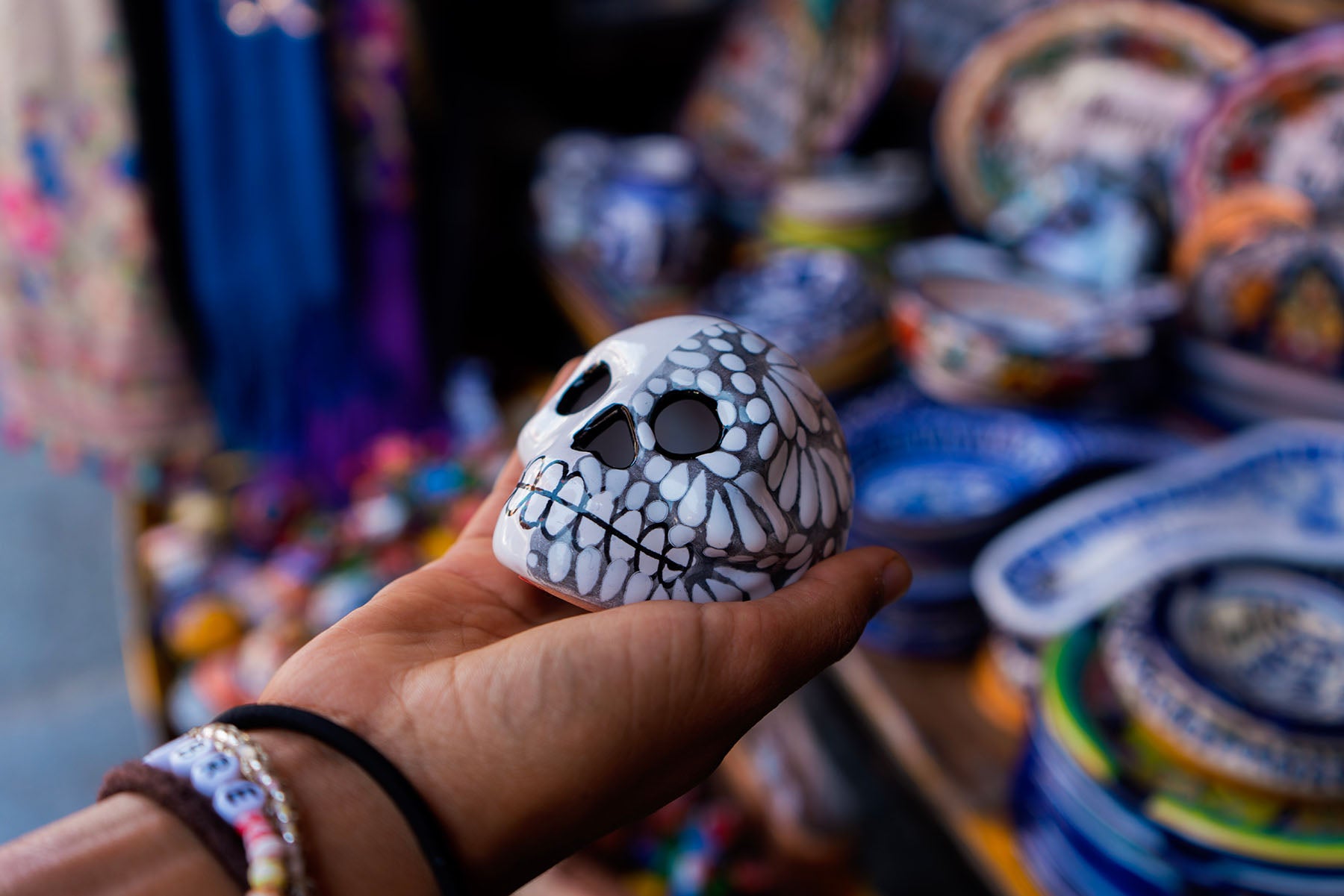 Close up photo of a hand holding a skull for Dia de los Muertos