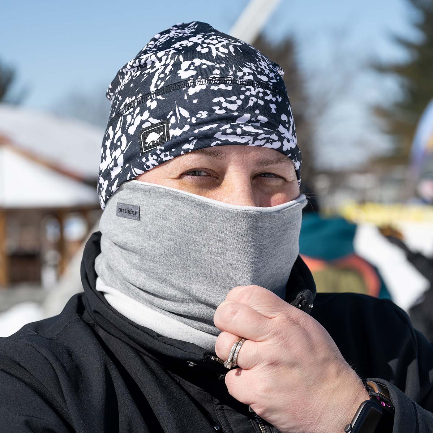 photo of woman adjusting neck gaiter to cover face