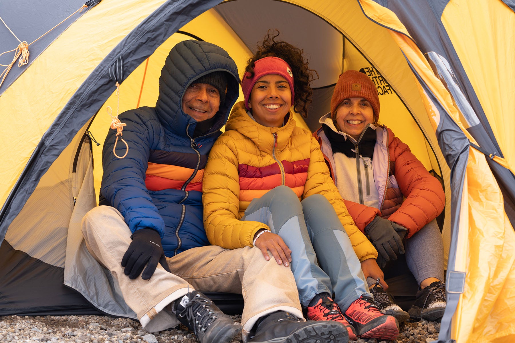 Photo of Vanessa sitting in tent opening with her parents