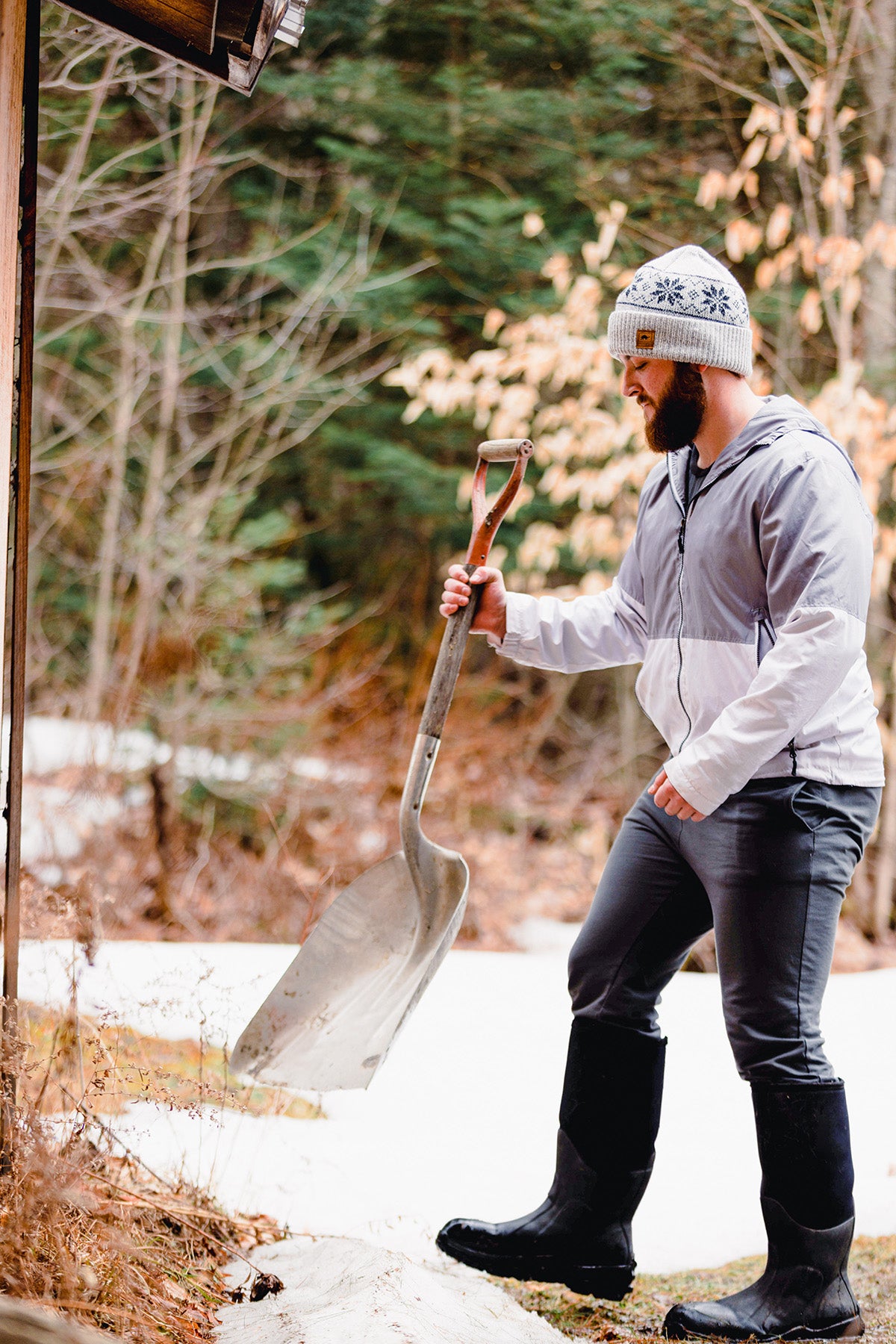 photo of man wearing beanie starting to shovel snow