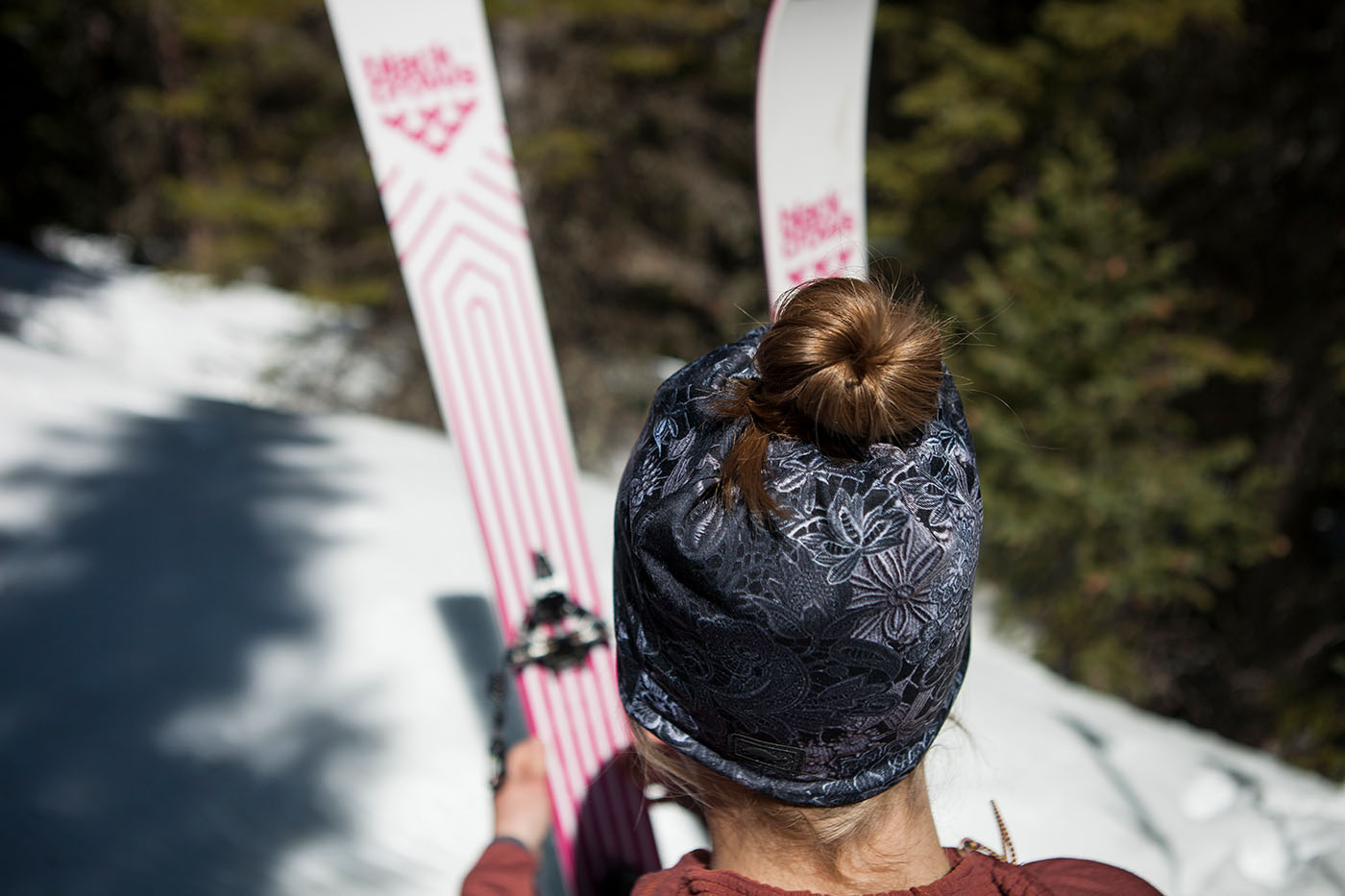 photo of back of woman's head showing ponytail going through beanie