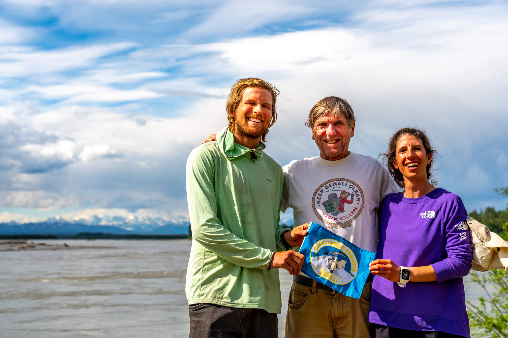 Joey Sackett, Roger Robinson, and Sophia Schwartz hold our team’s Sustainable Summits flag