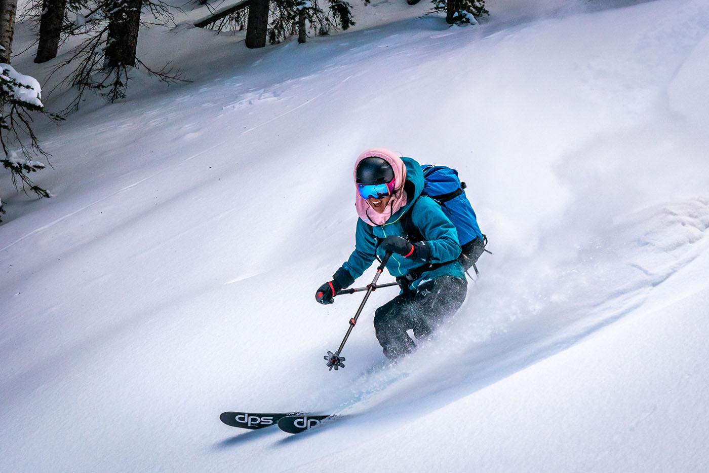 photo of downhill skier turning and kicking up snow