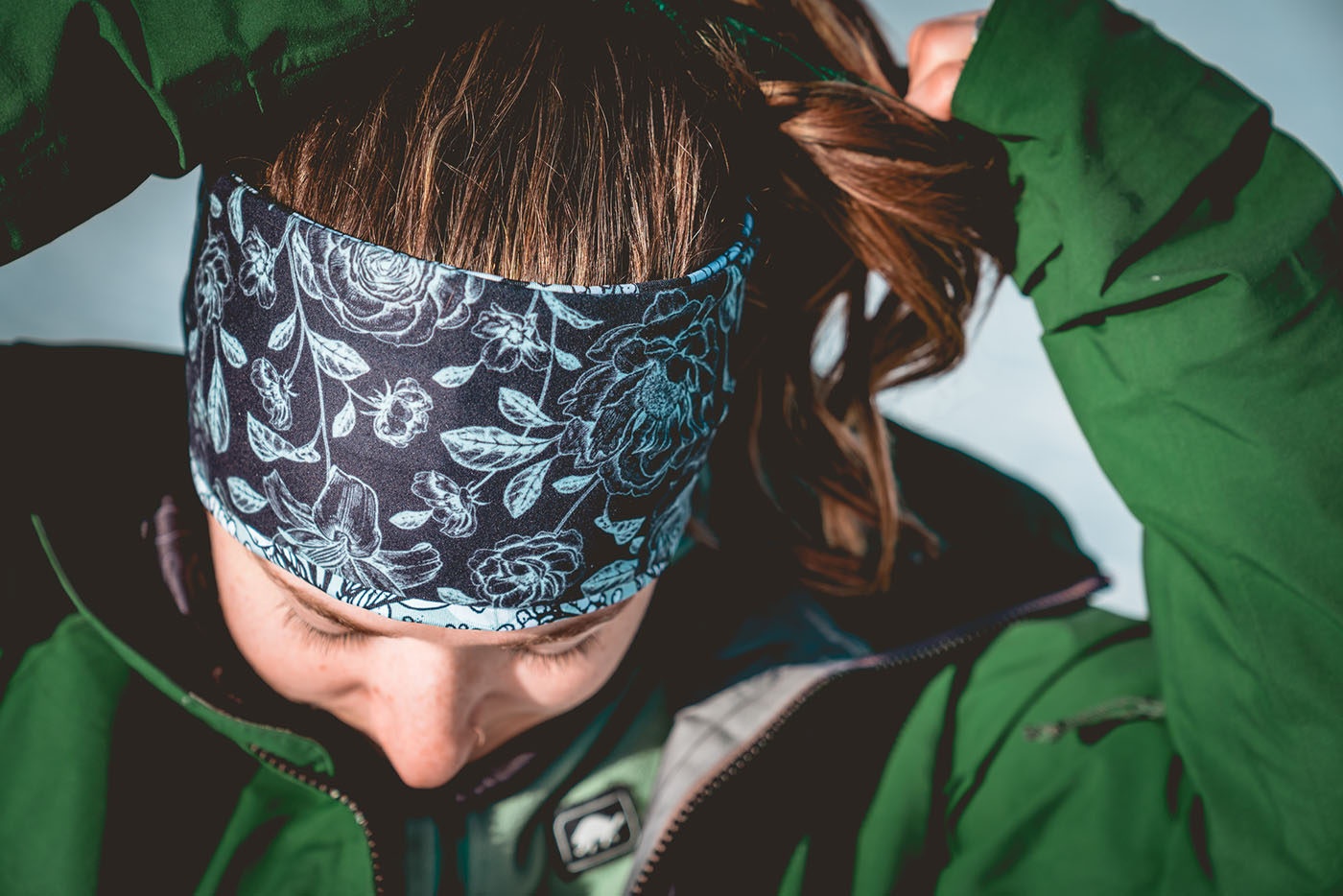 photo of woman adjusting ponytail wearing a headband