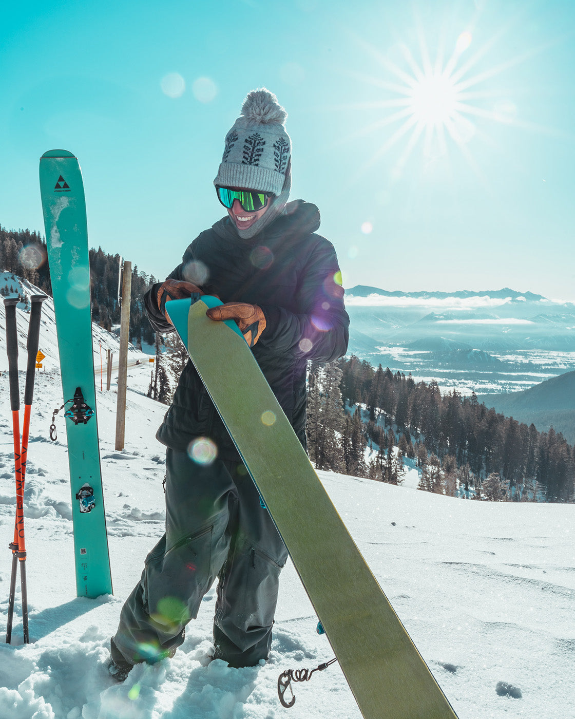 photo of skier wearing beanie pulling skins off ski