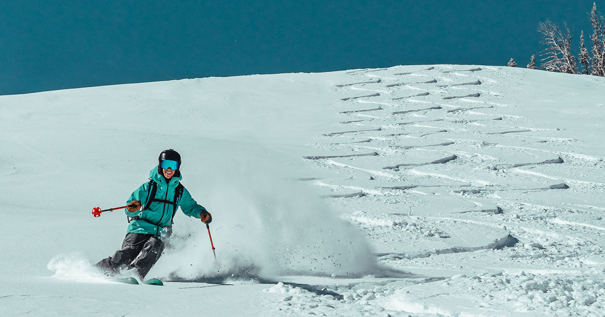 photo of skier making a run down mountain