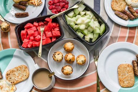 picture of cut up fruit, muffins and hash browns on a picnic table