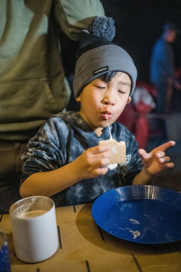 picture of boy taking bite out of a s'more