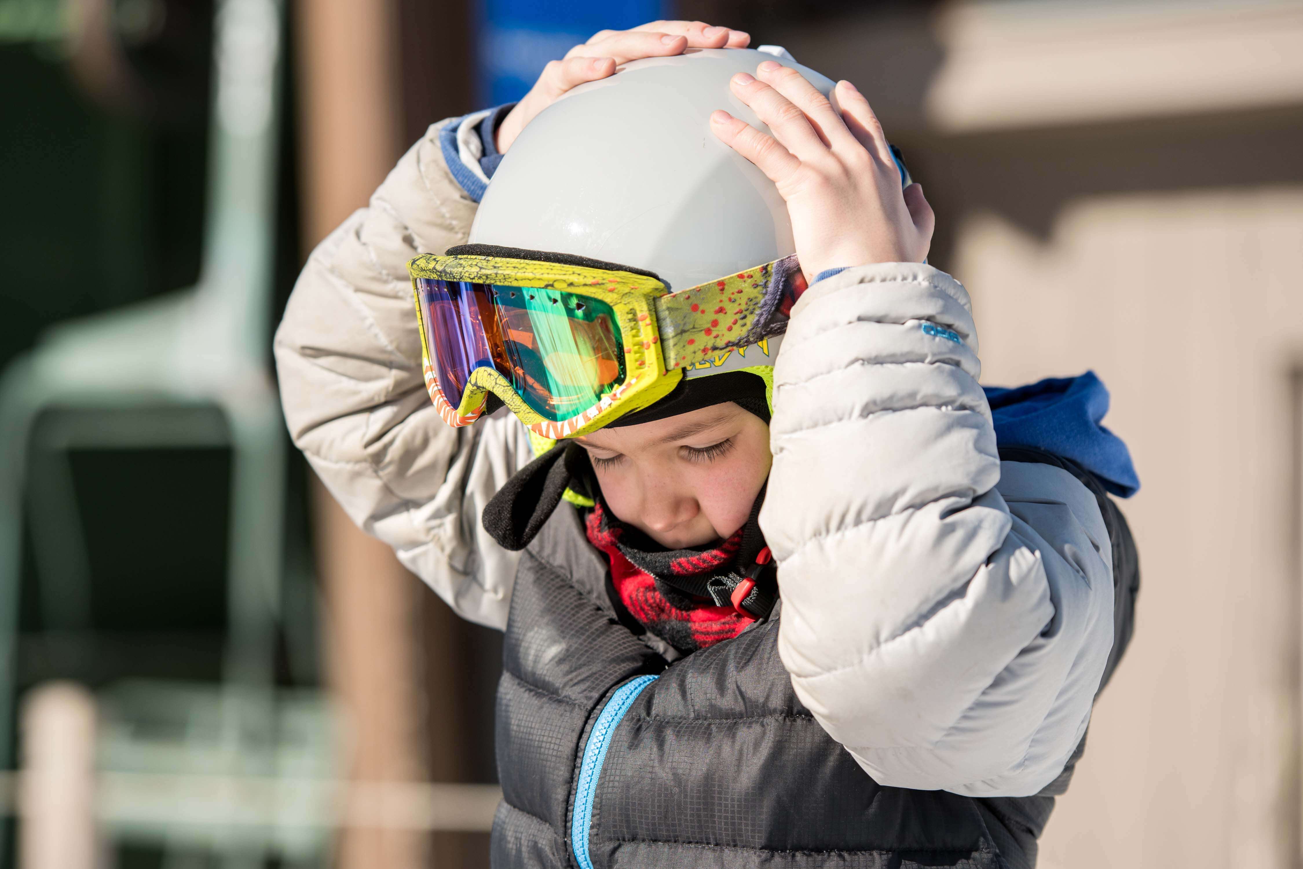 Child adjusting ski helmet