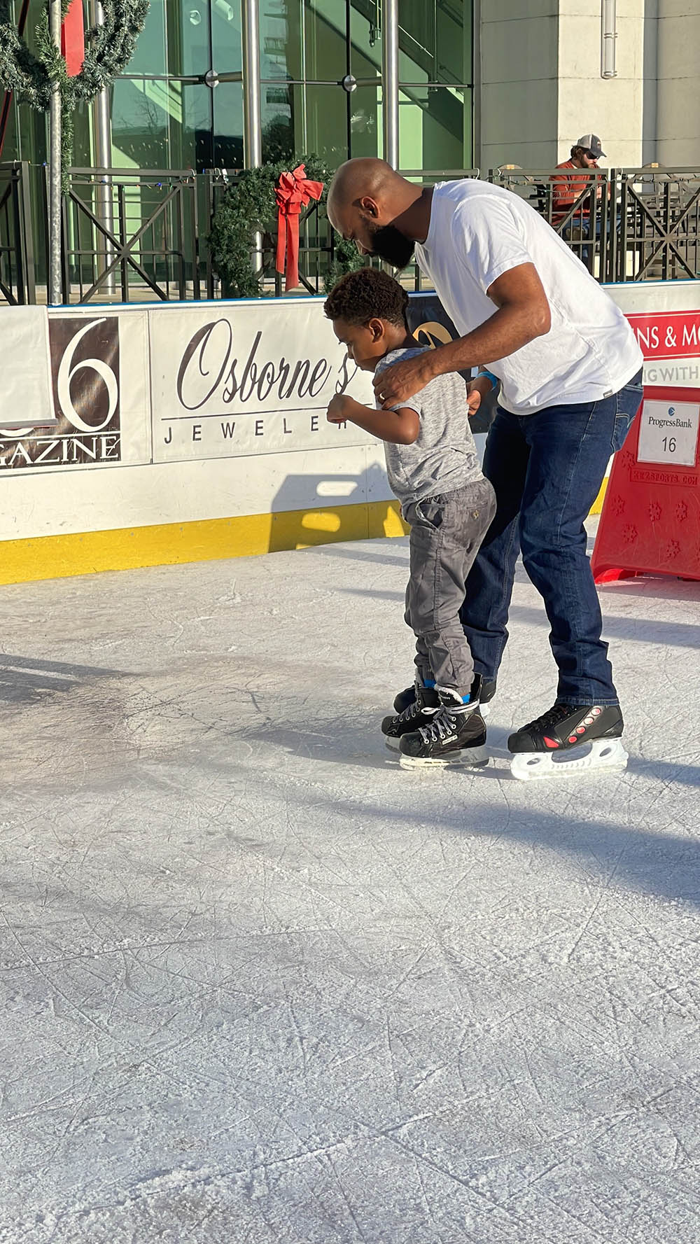 boy with father learning to ice skate