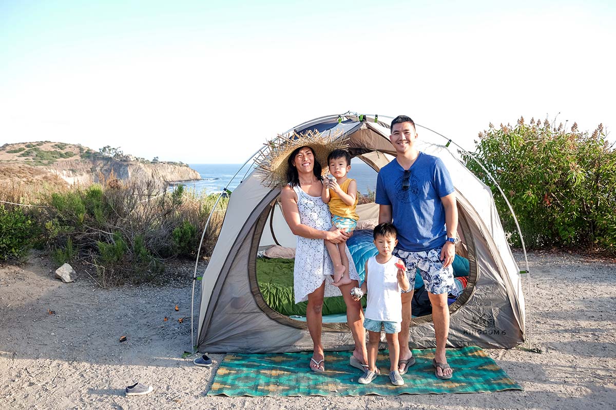 family camping posing in front of tent