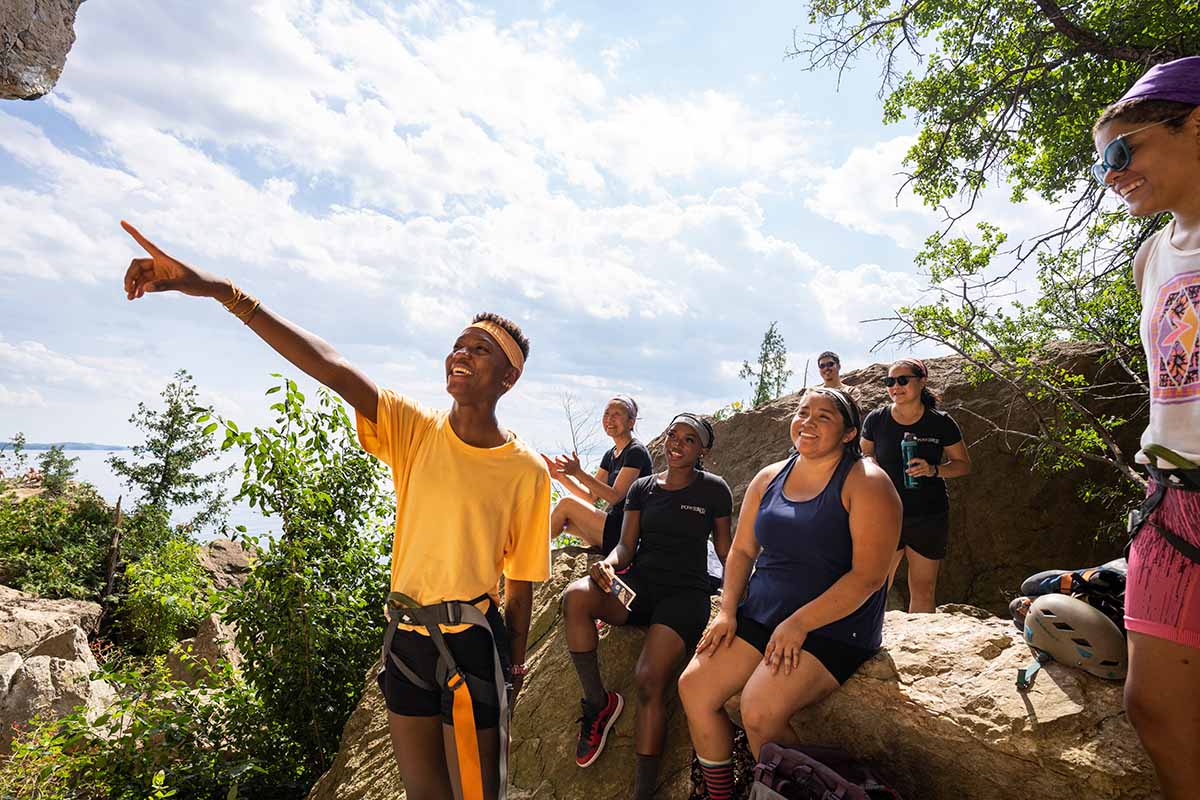 group of friends taking a break on rocks while hiking