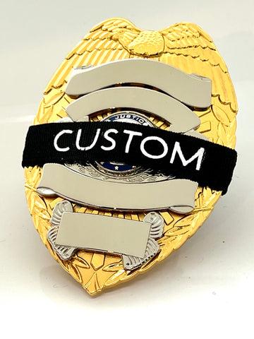 Image of a Badgeart Custom Printed mourning band on a gold and silver badge. Customize with a variety of agency initials offered by badgeart custom mourning bands for police officers, firefighters and others."