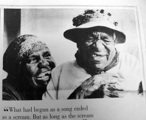 Old newspaper article image of Gloria Petyarre and Emily Kame Kngwarreye laughing. Captioned "What had begun as a song ended as a scream".