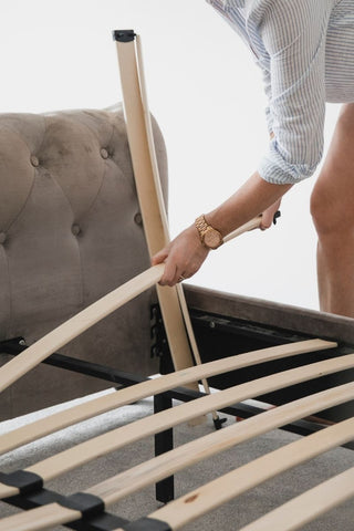 girl putting on slats to the bed