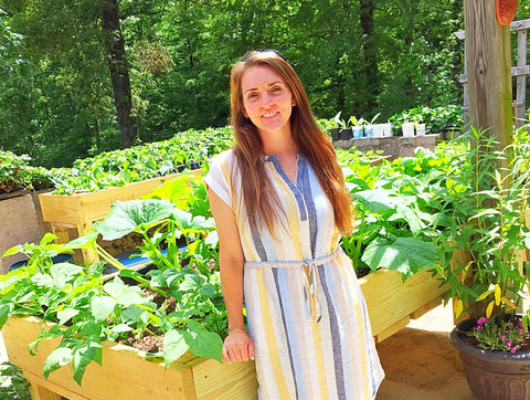 Cottagecore raised bed garden on patio with woman in front