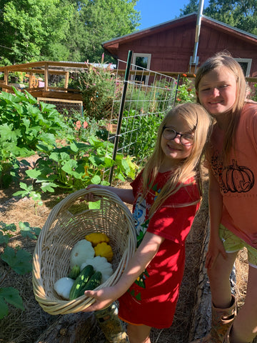 Girls with a basket of veggies from a cottage garden
