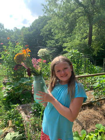 Girl Holding a vase of flowers gathered from the garden