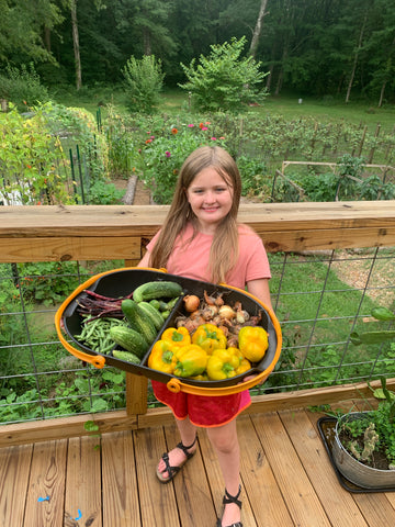 Girl holding a large basket of veggies