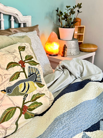 Cottagecore bedroom with quilts, pillows, and plants