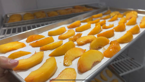 Peach Slices on cooking sheet in freezer