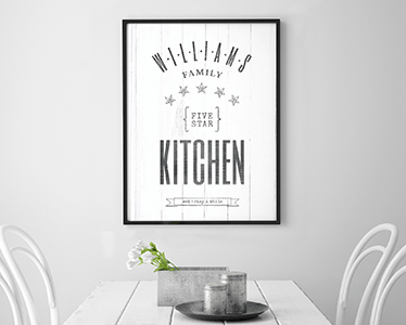 Five Star Kitchen personalized print framed in a black frame hanging over a dining table