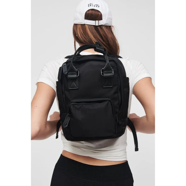 model wearing a black small backpack