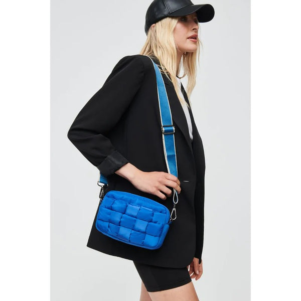 Woman carrying a blue quilted crossbody bag 