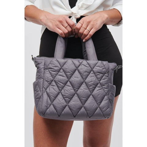 woman holding a Sol and Selene gray puffer mini tote