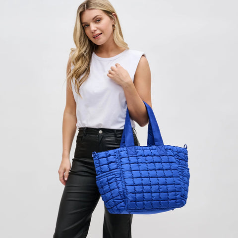 a model carrying a blue tote bag