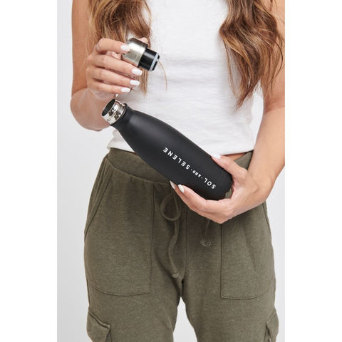 a model holding a black Sol and Selene water bottle