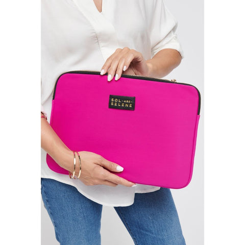 a model holding a bright pink neoprene laptop sleeve