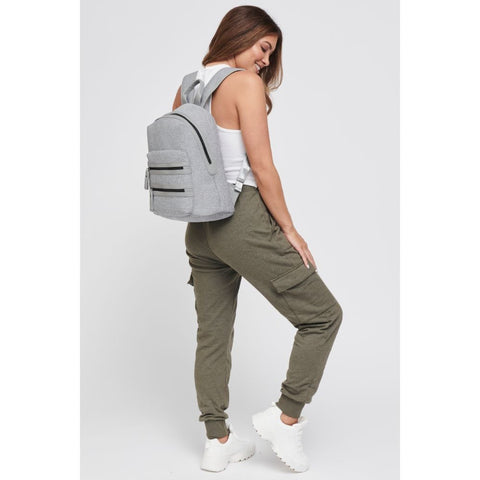 a model wearing a green cargo pants and a light gray backpack
